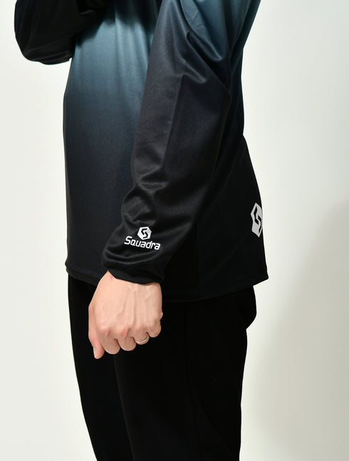 スクアドラ / グラフィックロングスリーブプラクティスシャツ ジムなどの屋内はもちろん、屋外でのトレーニングにも最適な長袖プラクティスシャツ。